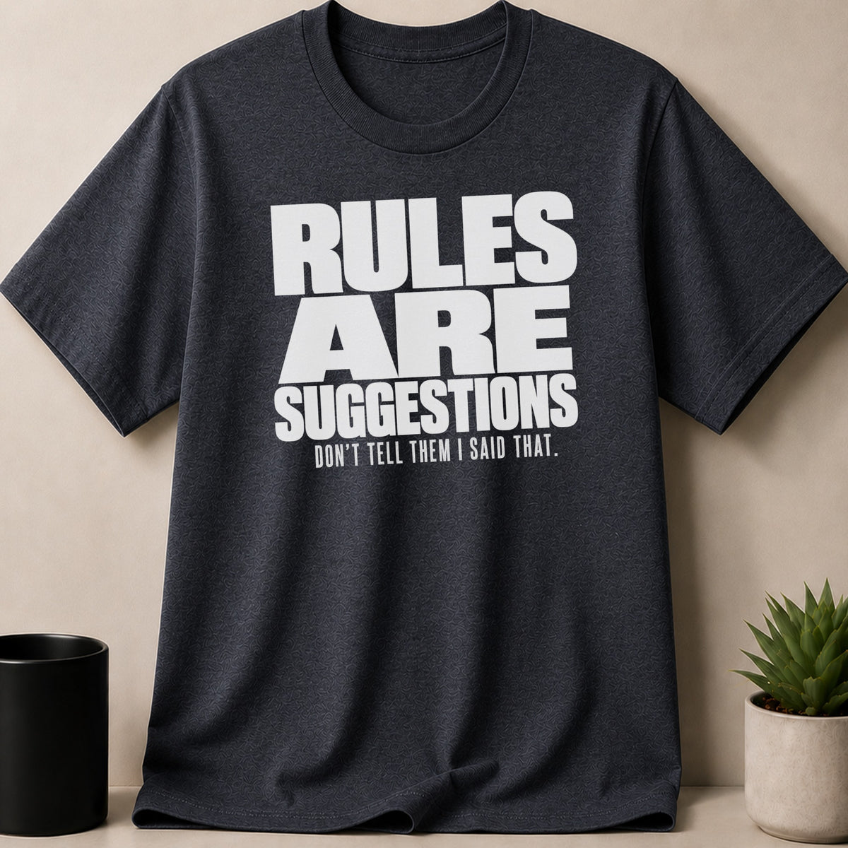 Dark grey t-shirt with white text: "RULES ARE SUGGESTIONS. DON'T TELL THEM I SAID THAT."