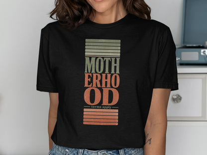 Black t-shirt with "MOTHERHOOD" text and "terms apply" with textured stripes.