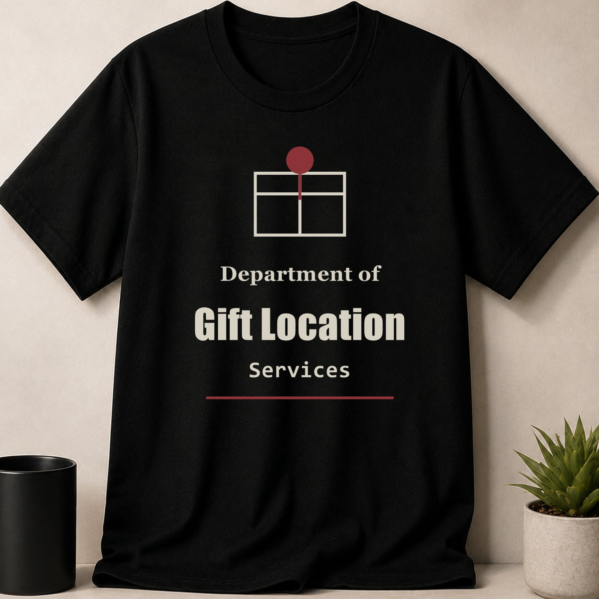 A black crewneck t-shirt featuring a stylized gift box icon and the text Department of Gift Location Services.