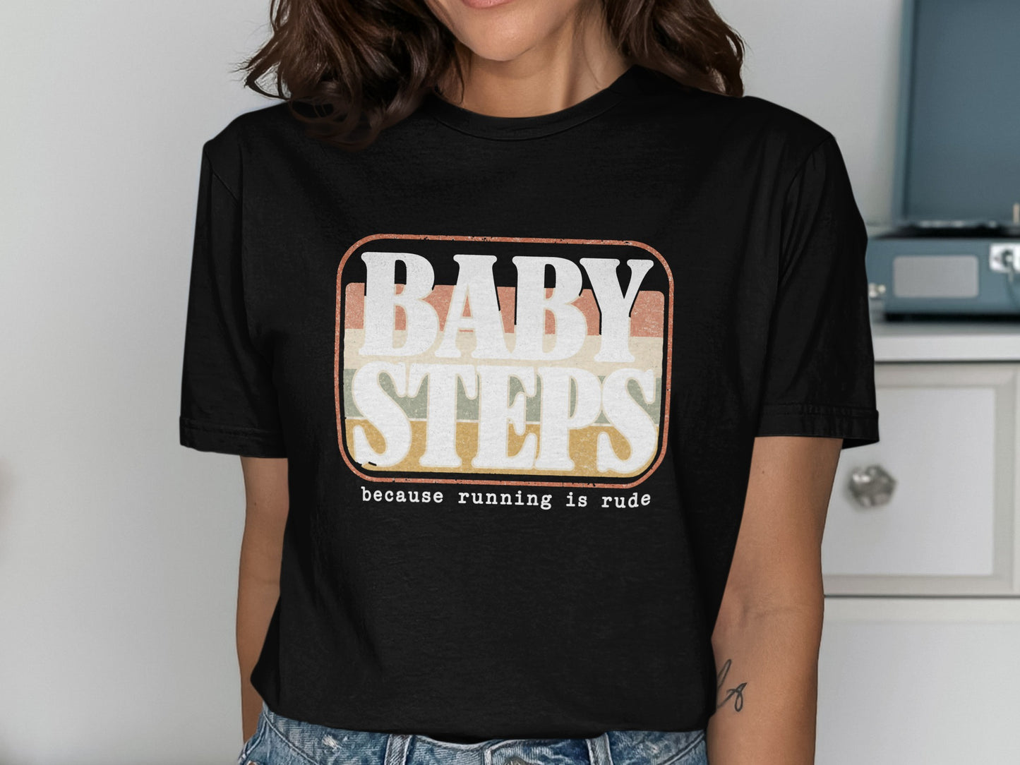 Black t-shirt with retro graphic text "BABY STEPS because running is rude."