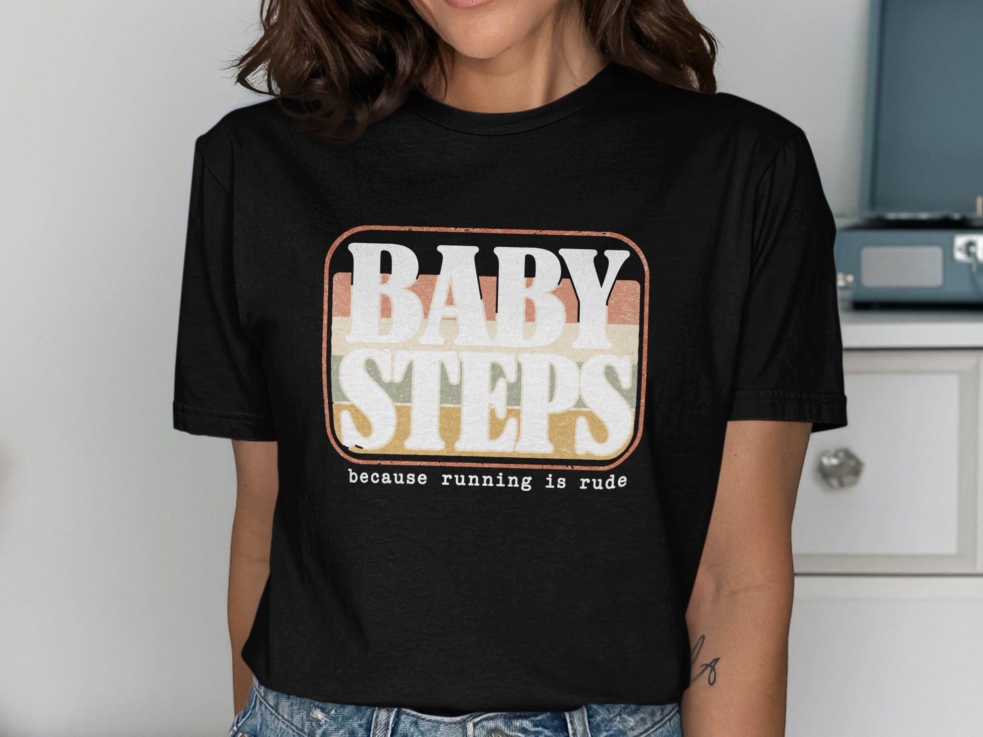 Black t-shirt with retro graphic text "BABY STEPS because running is rude."