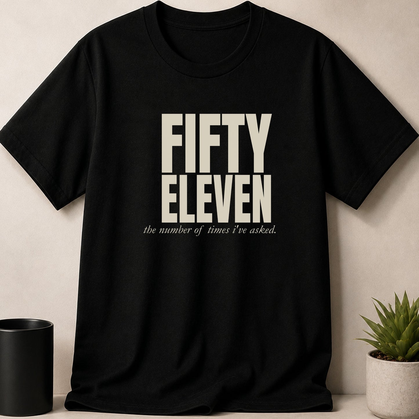Black t-shirt with "FIFTY ELEVEN" and "the number of times I've asked." text.