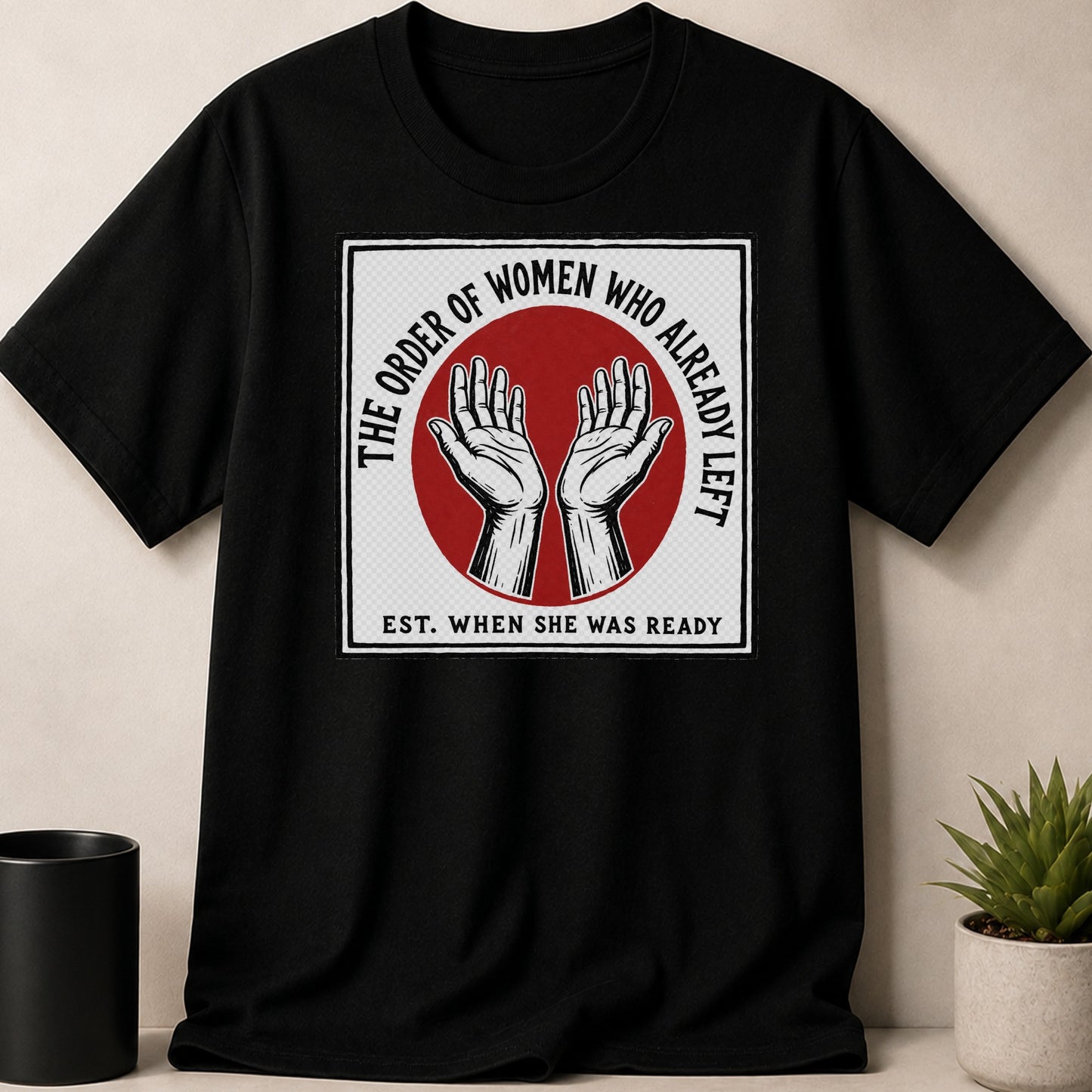 Black t-shirt with "The Order of Women Who Already Left Est. When She Was Ready" text and hands graphic.