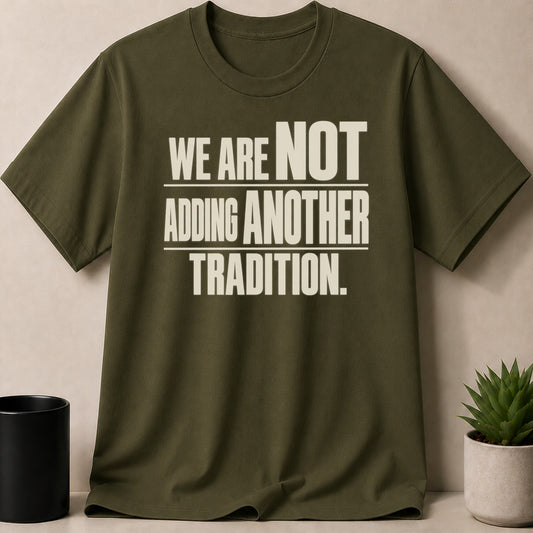 An olive green crewneck t-shirt featuring cream text that reads WE ARE NOT ADDING ANOTHER TRADITION.