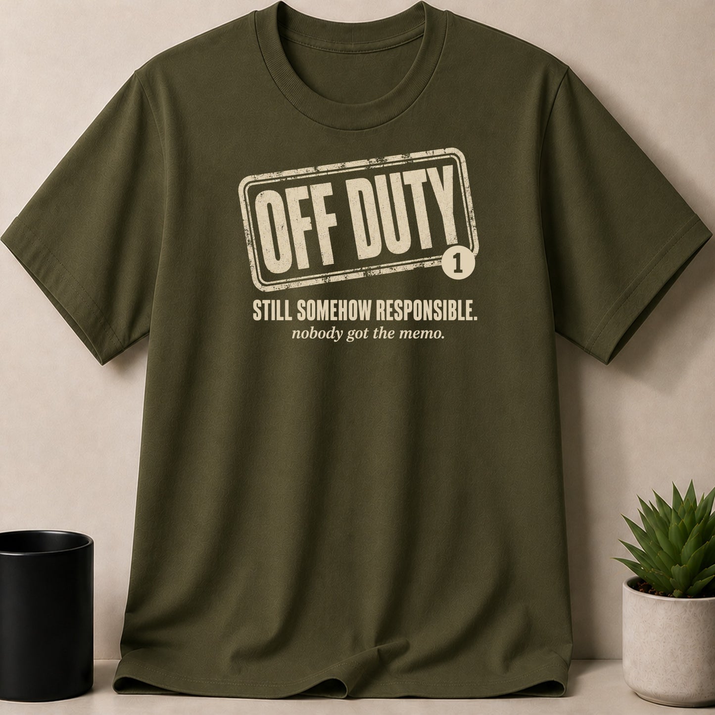 Olive green t-shirt with distressed "OFF DUTY" text and "STILL SOMEHOW RESPONSIBLE."