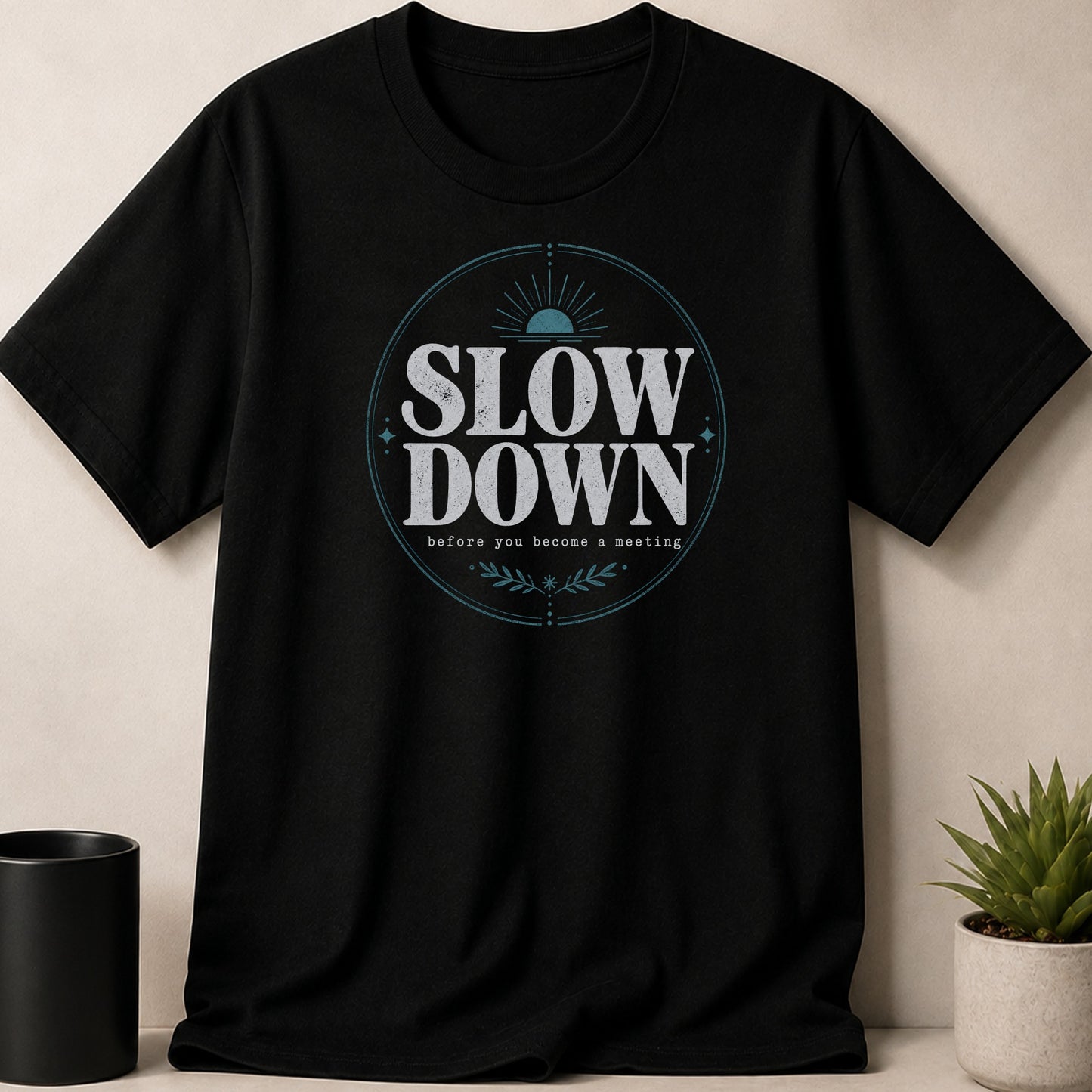 Black t-shirt with "SLOW DOWN before you become a meeting" circular graphic design.