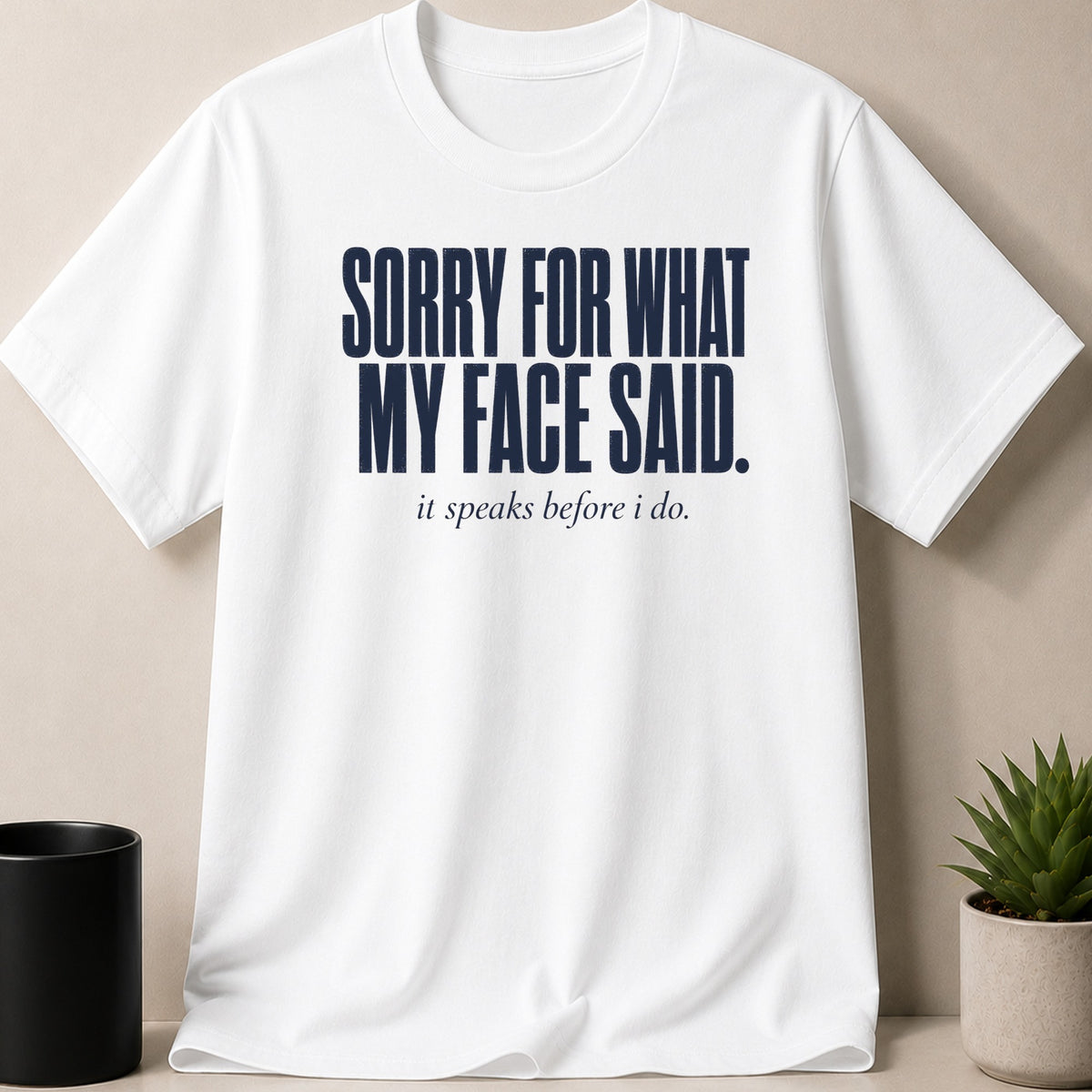 White t-shirt with dark blue text: "Sorry for what my face said. It speaks before I do."