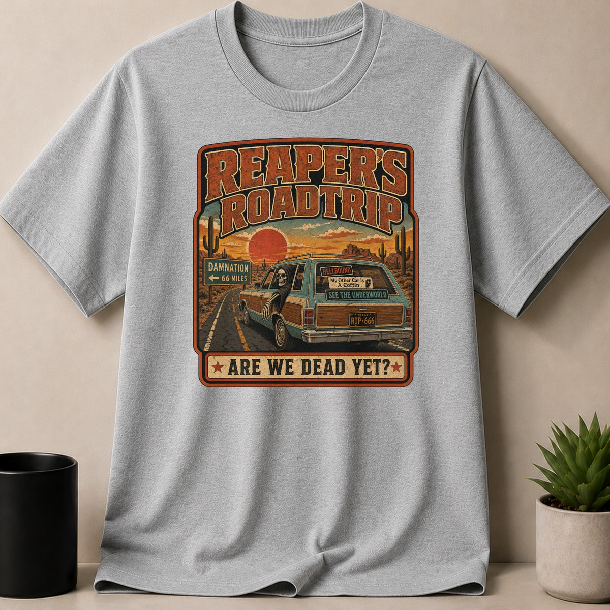 The Reaper's Roadtrip design on a gray t-shirt with a skeleton driving a station wagon.