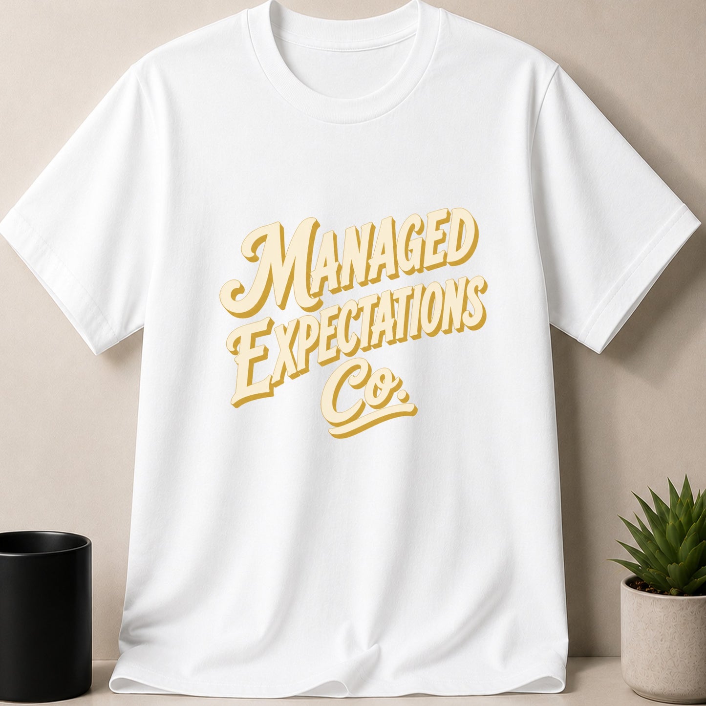 White t-shirt with yellow text "MANAGED EXPECTATIONS Co."