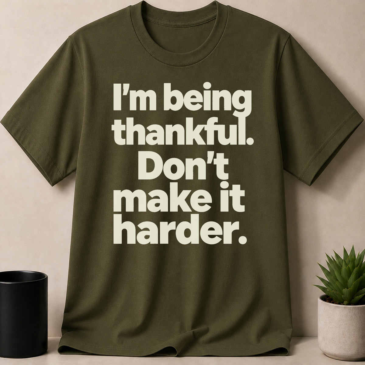 Olive green t-shirt with white text: "I'm being thankful. Don't make it harder."