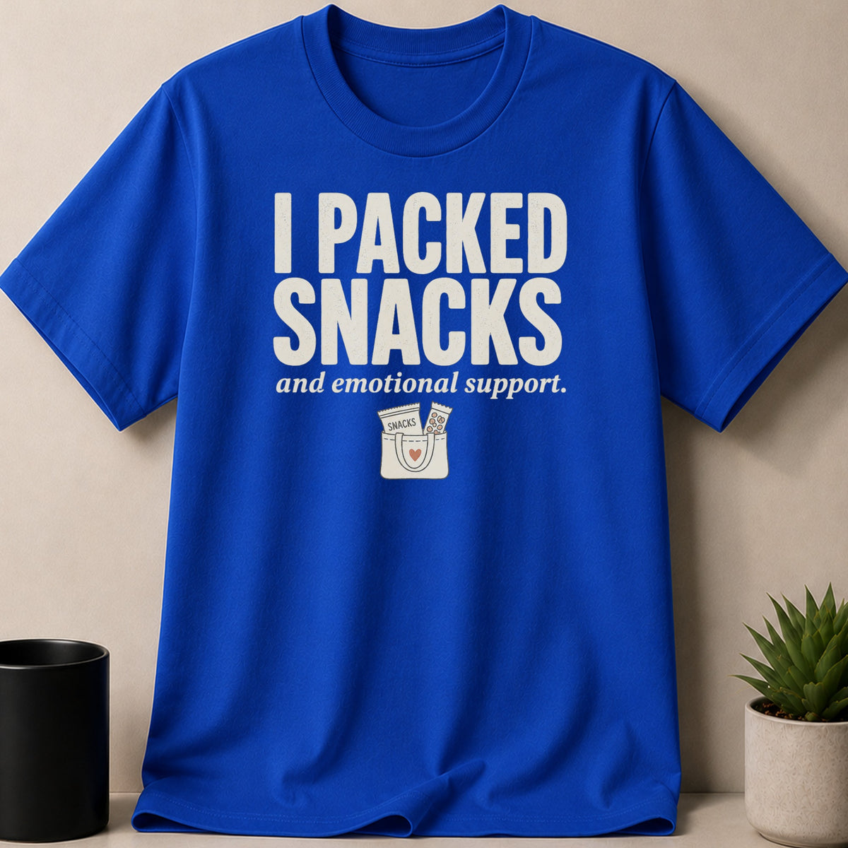 Blue t-shirt with "I PACKED SNACKS and emotional support." and a graphic.