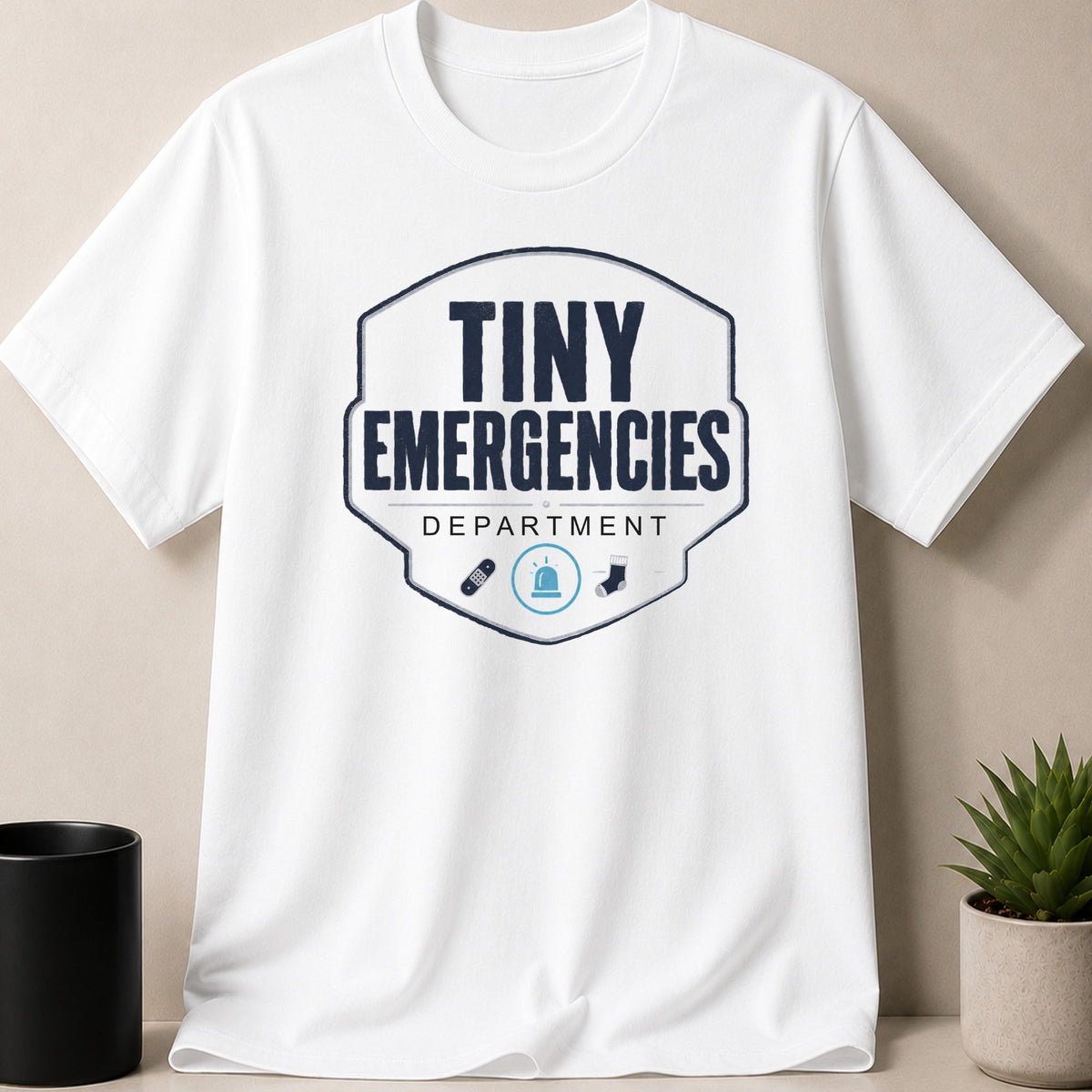 White t-shirt with "Tiny Emergencies Department" text and cute graphics.