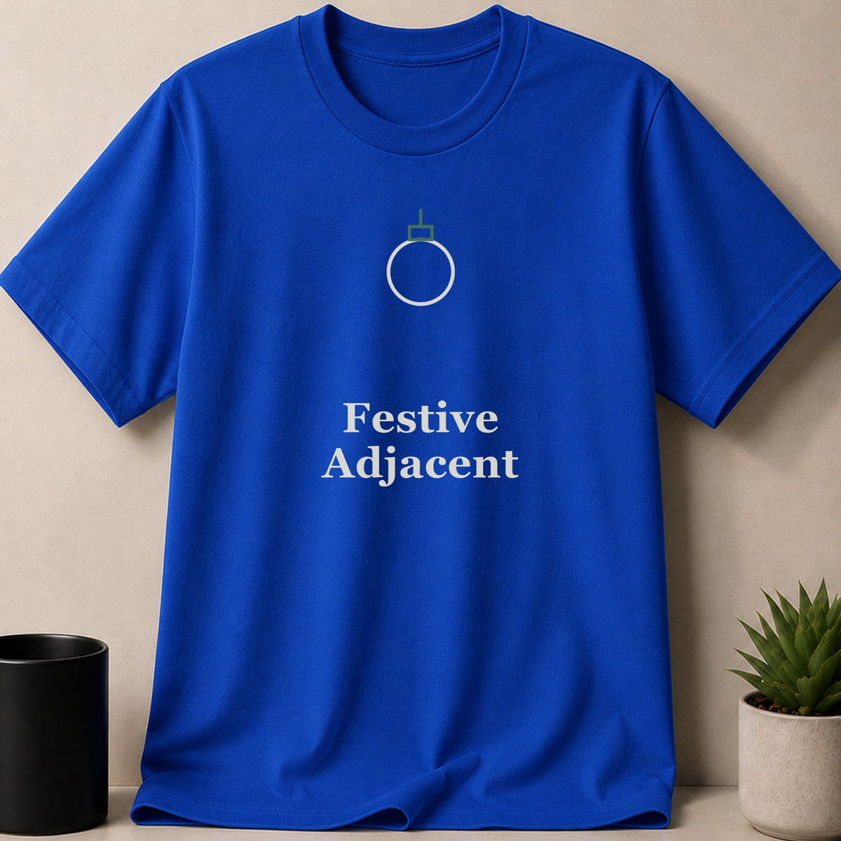 A royal blue crewneck t-shirt featuring a minimalist white ornament graphic and the text Festive Adjacent.