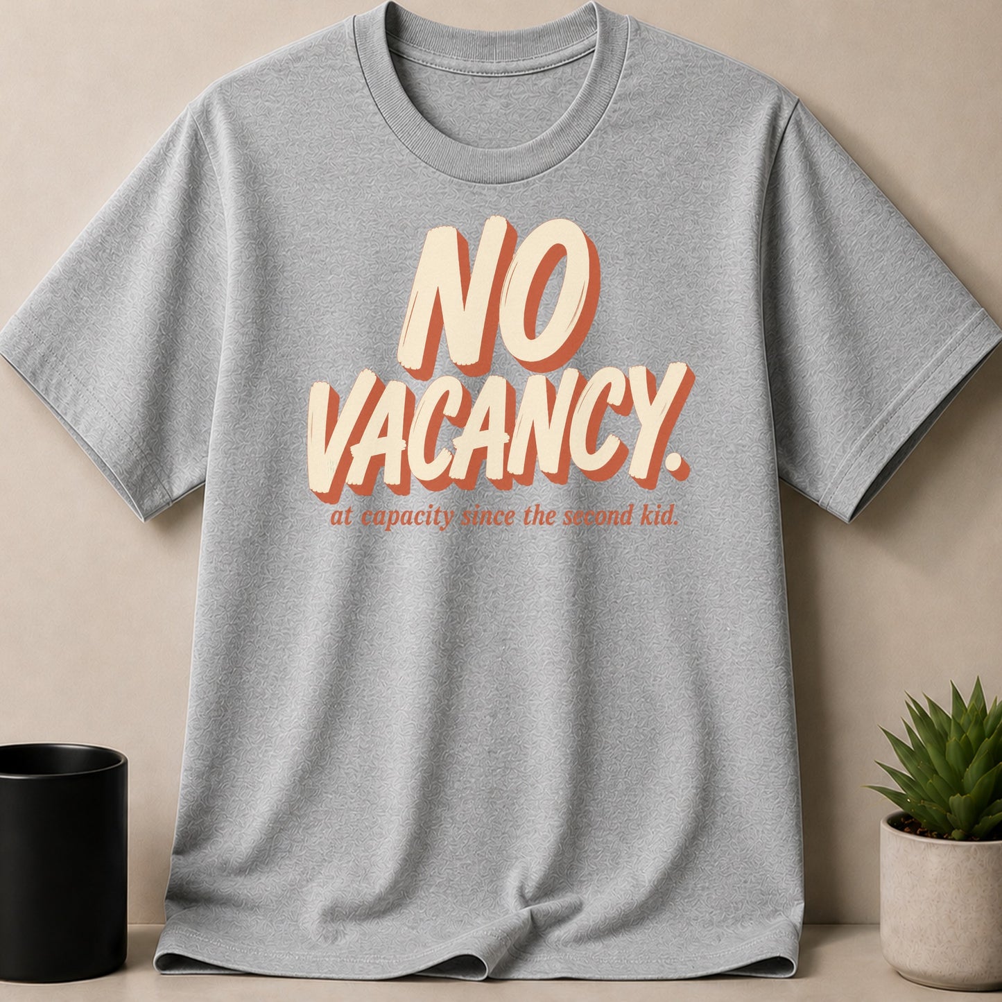 Grey t-shirt with "NO VACANCY. at capacity since the second kid." text.
