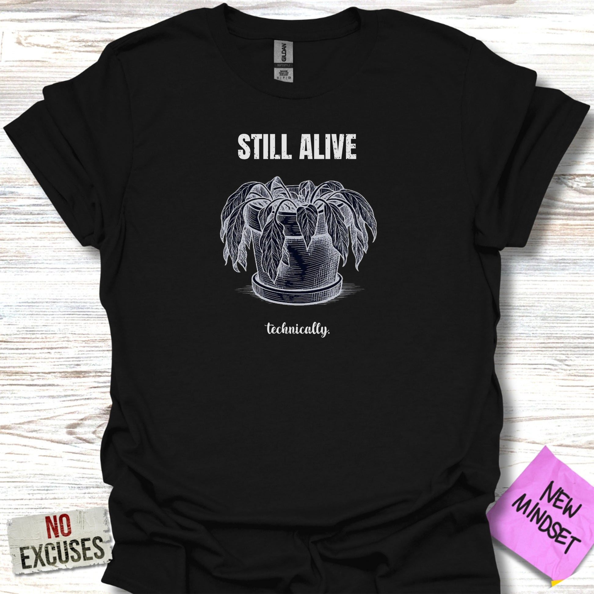 Black t-shirt with "STILL ALIVE technically." text and a potted plant illustration.