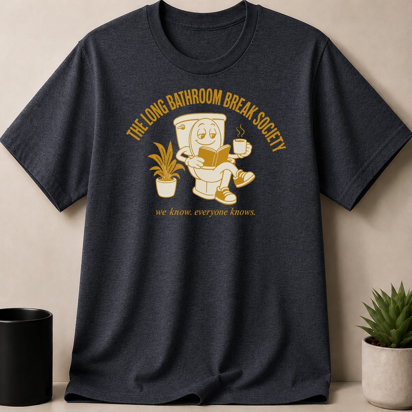 Dark t-shirt with graphic of toilet reading a book and drinking coffee.