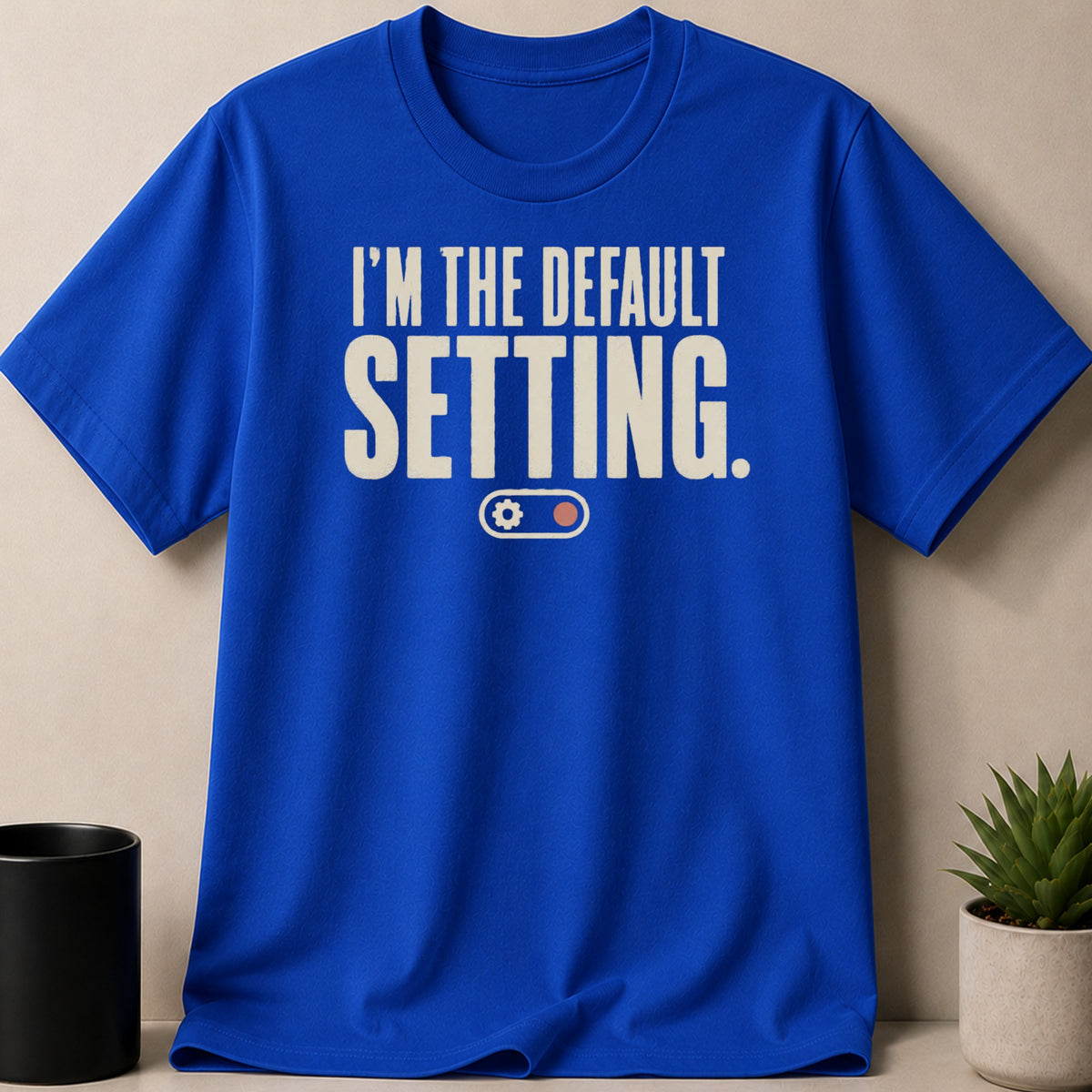 Royal blue t-shirt with "I'm the default setting." text and gear icon.