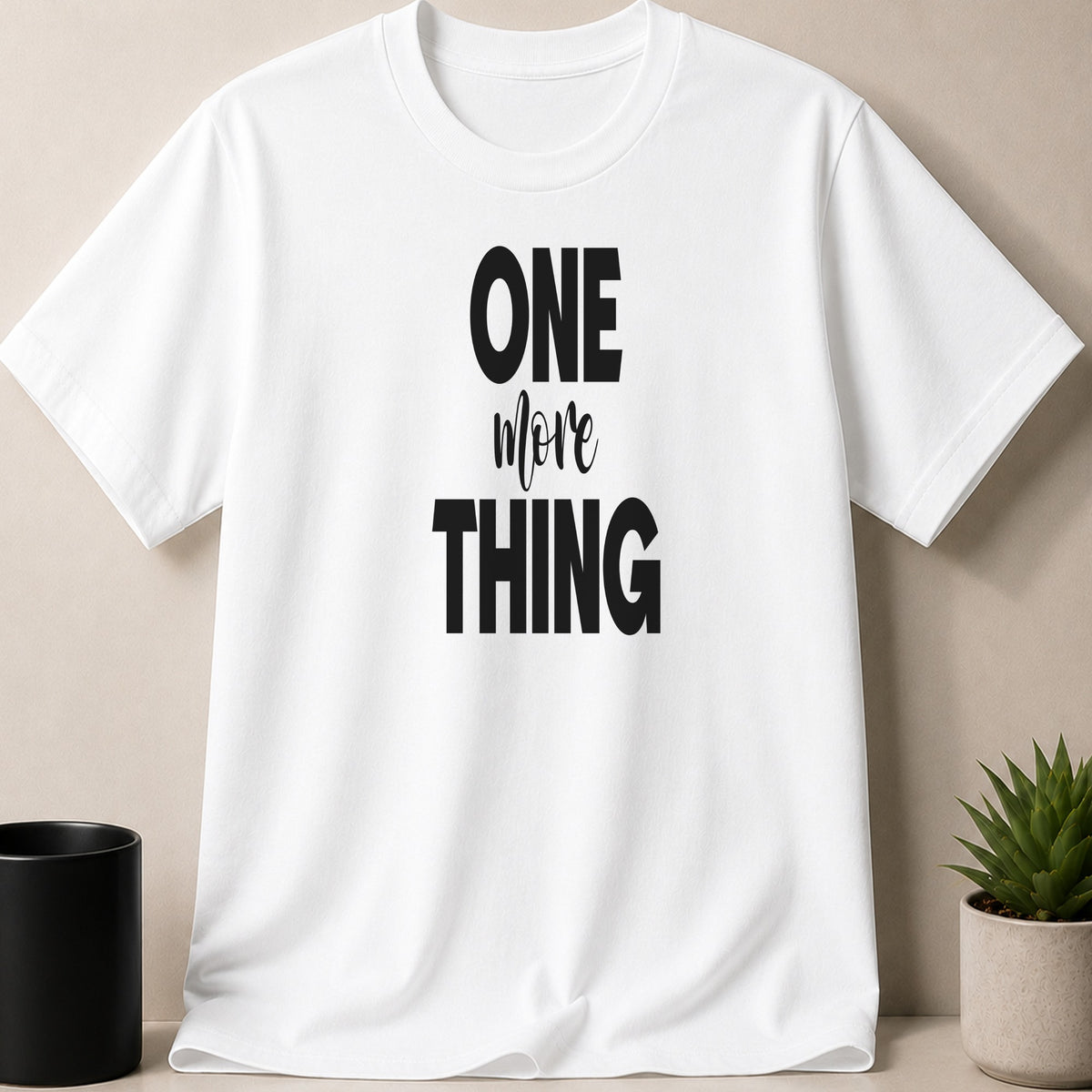 White t-shirt with black text reading "ONE more THING"