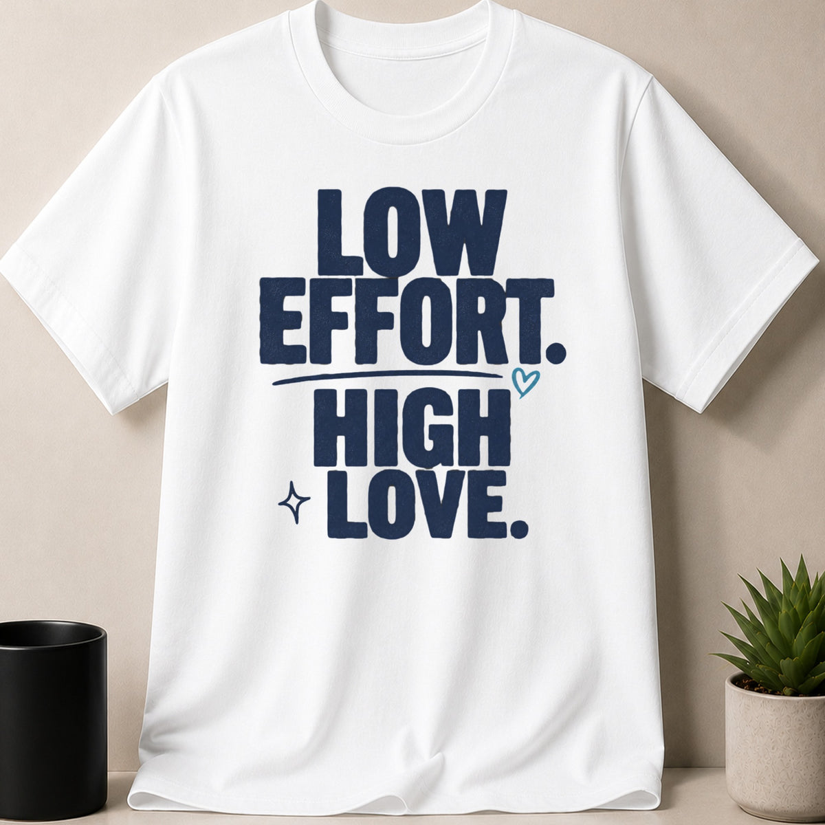 White t-shirt with navy text reading "LOW EFFORT. HIGH LOVE."