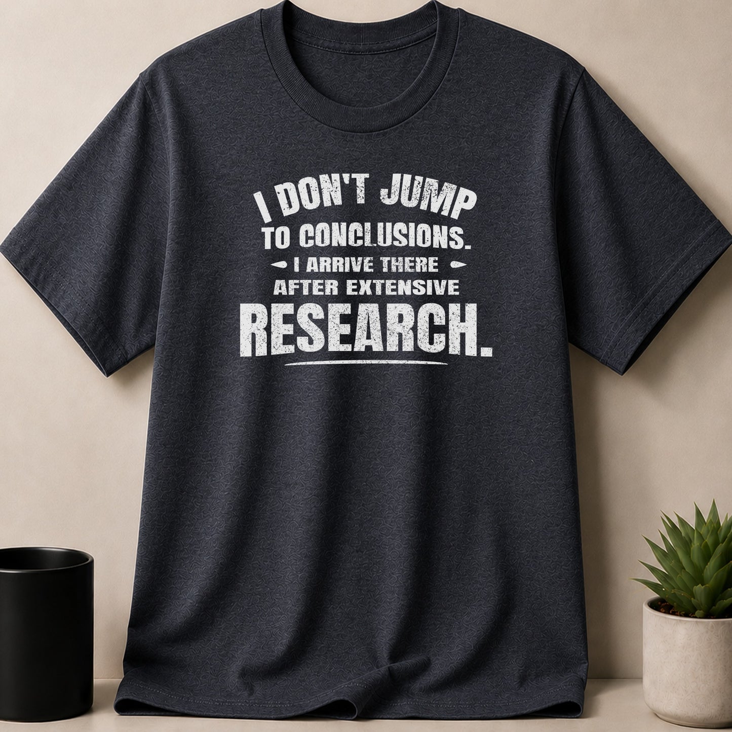 Dark grey t-shirt with white text: "I don't jump to conclusions. I arrive there after extensive research."