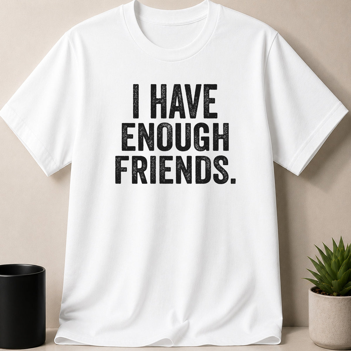 White t-shirt with black distressed text that reads "I HAVE ENOUGH FRIENDS."