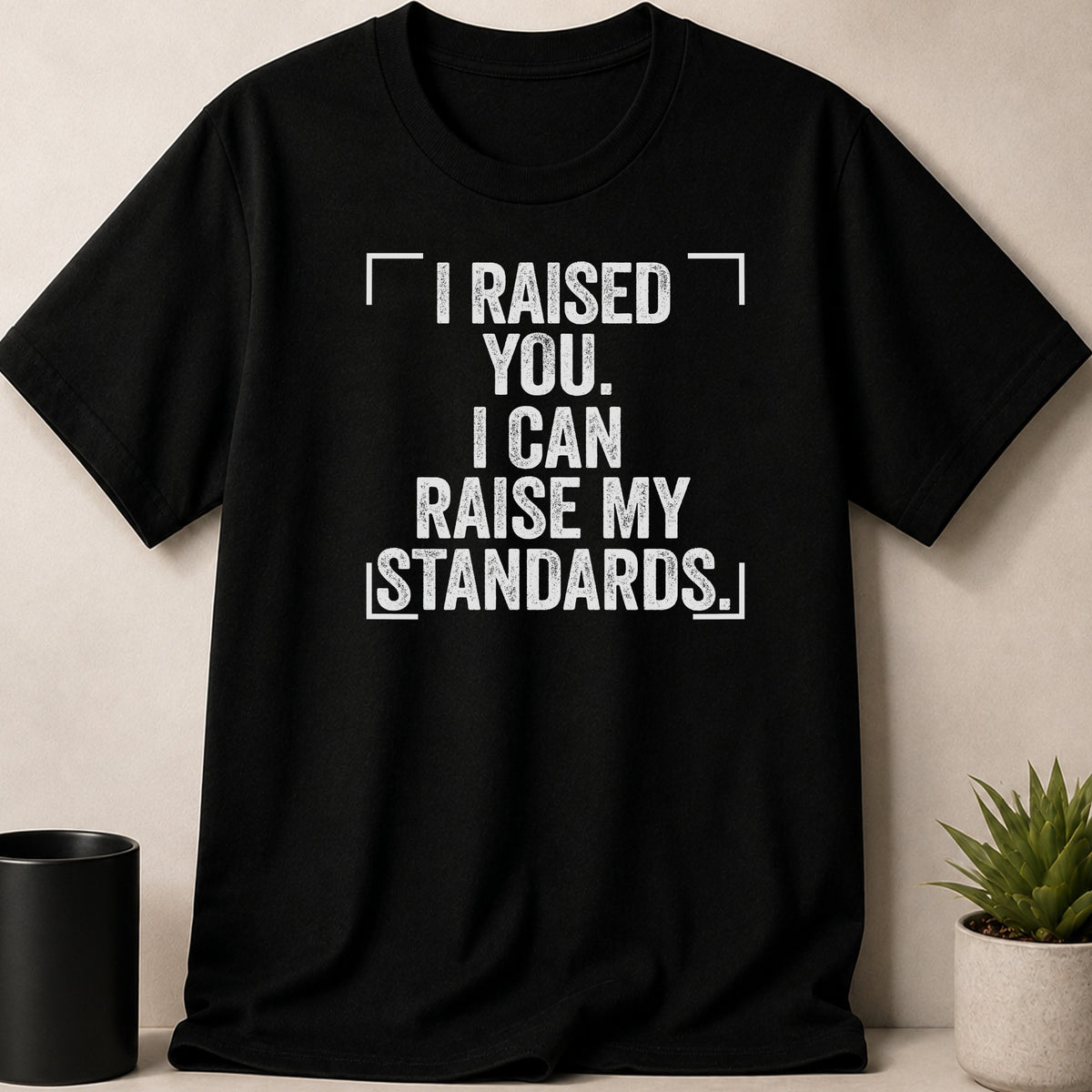 Black t-shirt with white text "I RAISED YOU. I CAN RAISE MY STANDARDS."