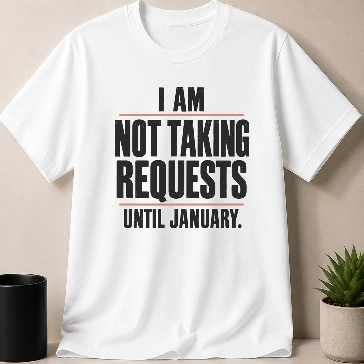 A white t-shirt printed with the black text I AM NOT TAKING REQUESTS UNTIL JANUARY.