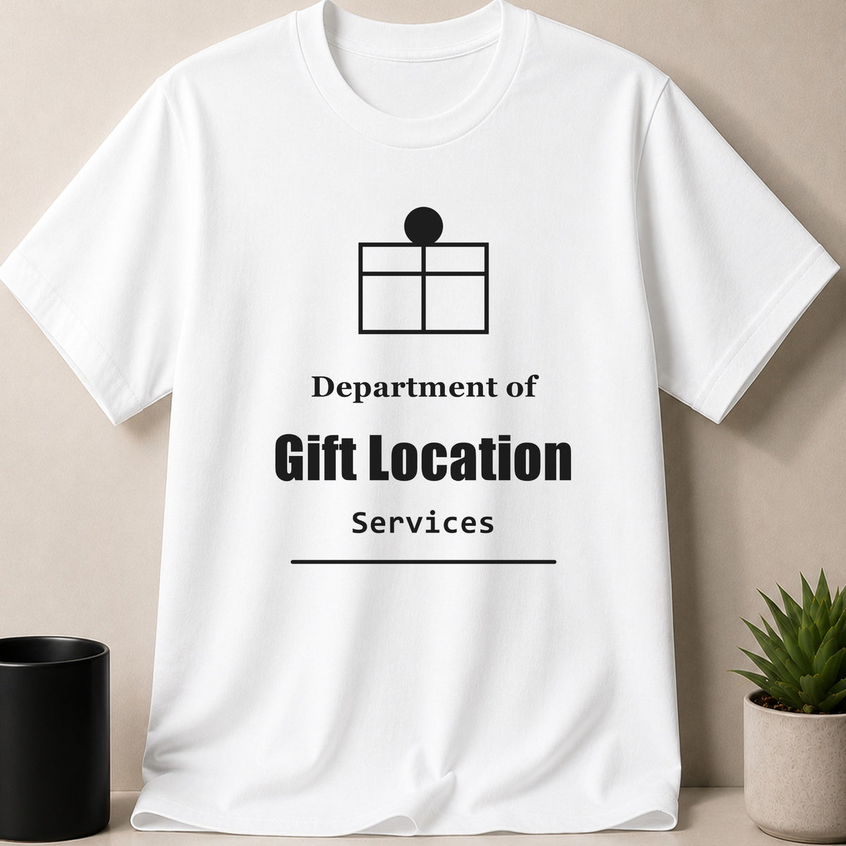 A white crewneck t-shirt displays a black gift box graphic above the text Department of Gift Location Services.