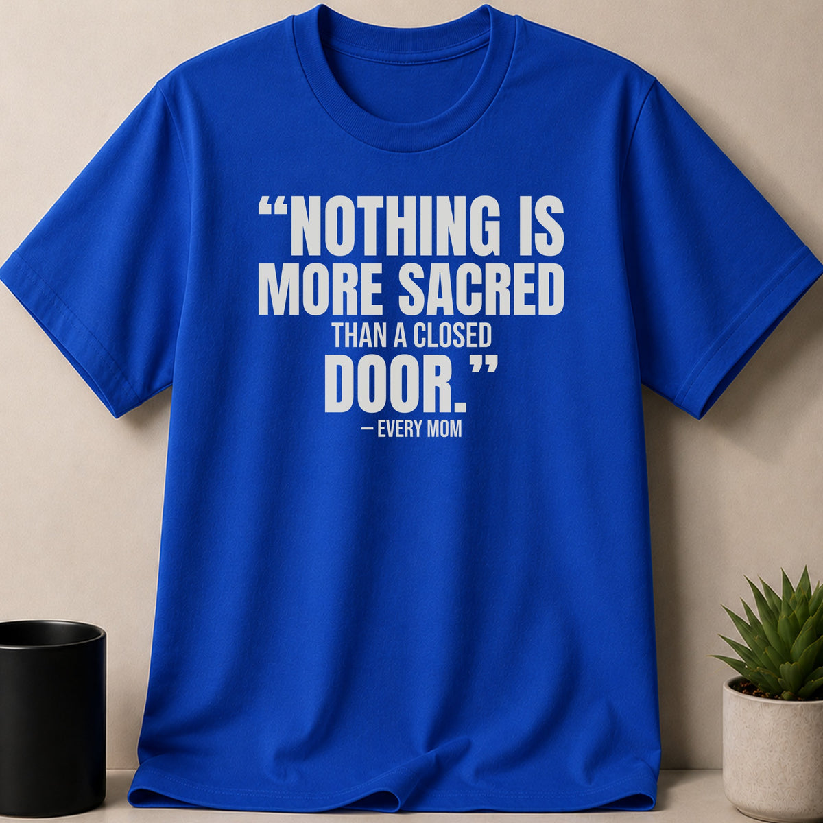 A royal blue crewneck t-shirt with white text that reads NOTHING IS MORE SACRED THAN A CLOSED DOOR. – EVERY MOM.