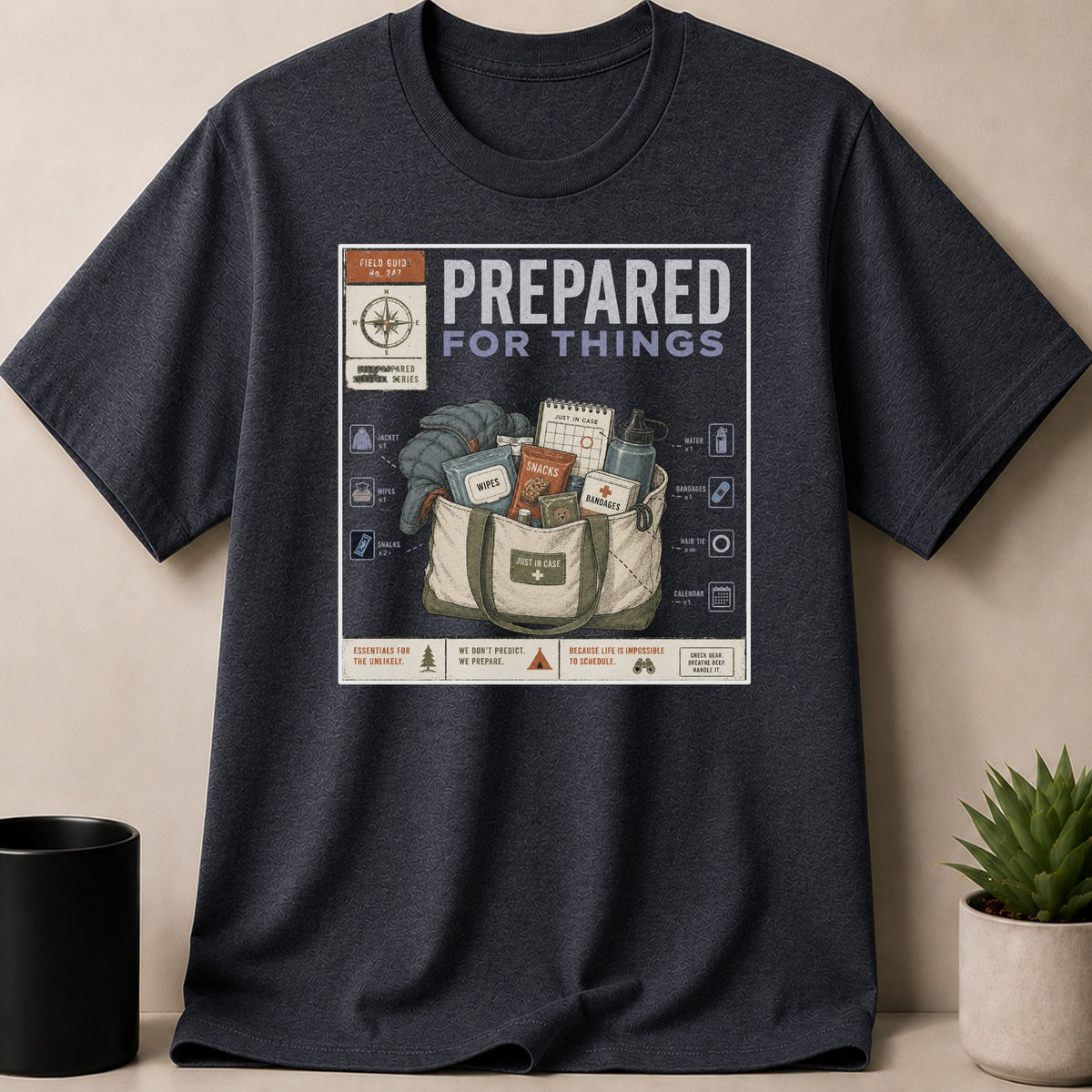 Dark Heather t-shirt — T-shirt graphic illustrating a bag of preparedness items with text "PREPARED FOR THINGS".