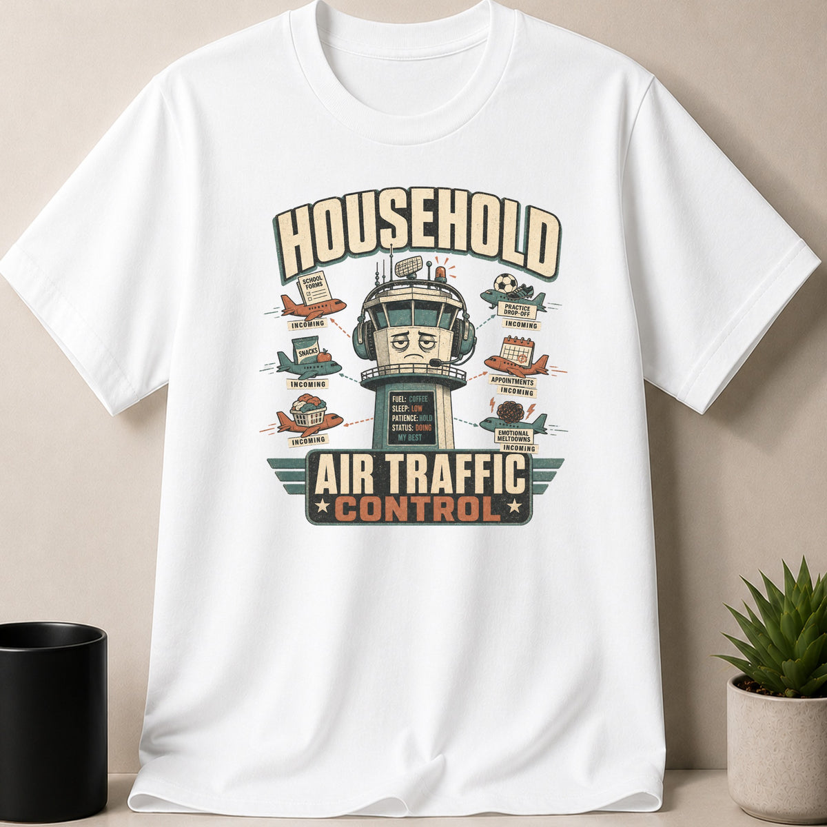 White t-shirt — T-shirt with "Household Air Traffic Control" graphic featuring planes carrying everyday tasks.