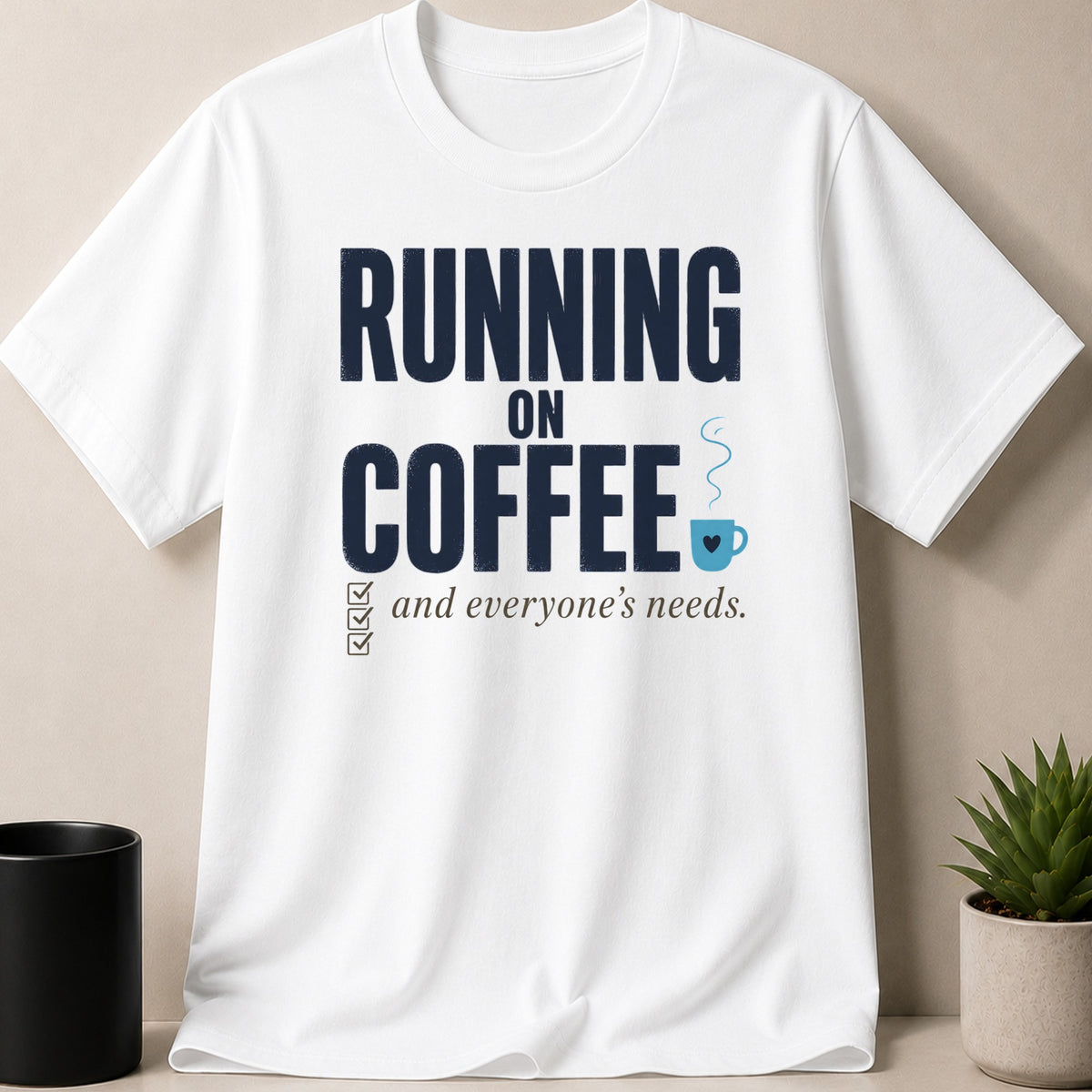 White t-shirt with navy text "RUNNING ON COFFEE and everyone's needs" and coffee cup graphic.