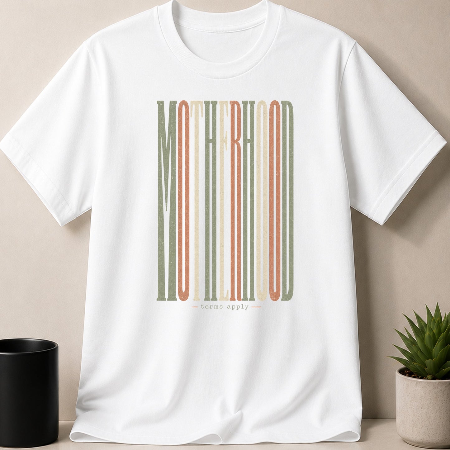 White t-shirt with "MOTHERHOOD" text in vertical stripes and "terms apply" below.