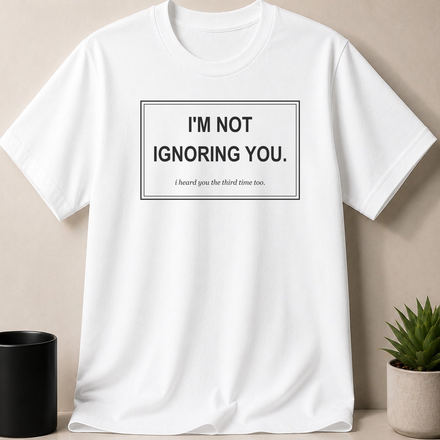 White t-shirt with text "I'm not ignoring you. I heard you the third time too."