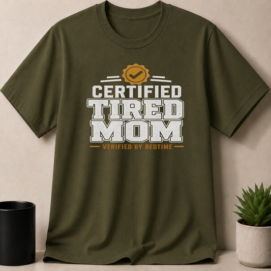 Green t-shirt with white text and yellow badge: CERTIFIED TIRED MOM VERIFIED BY BEDTIME.