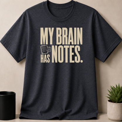 Dark t-shirt with cream text "MY BRAIN HAS NOTES." and small notepad graphic.