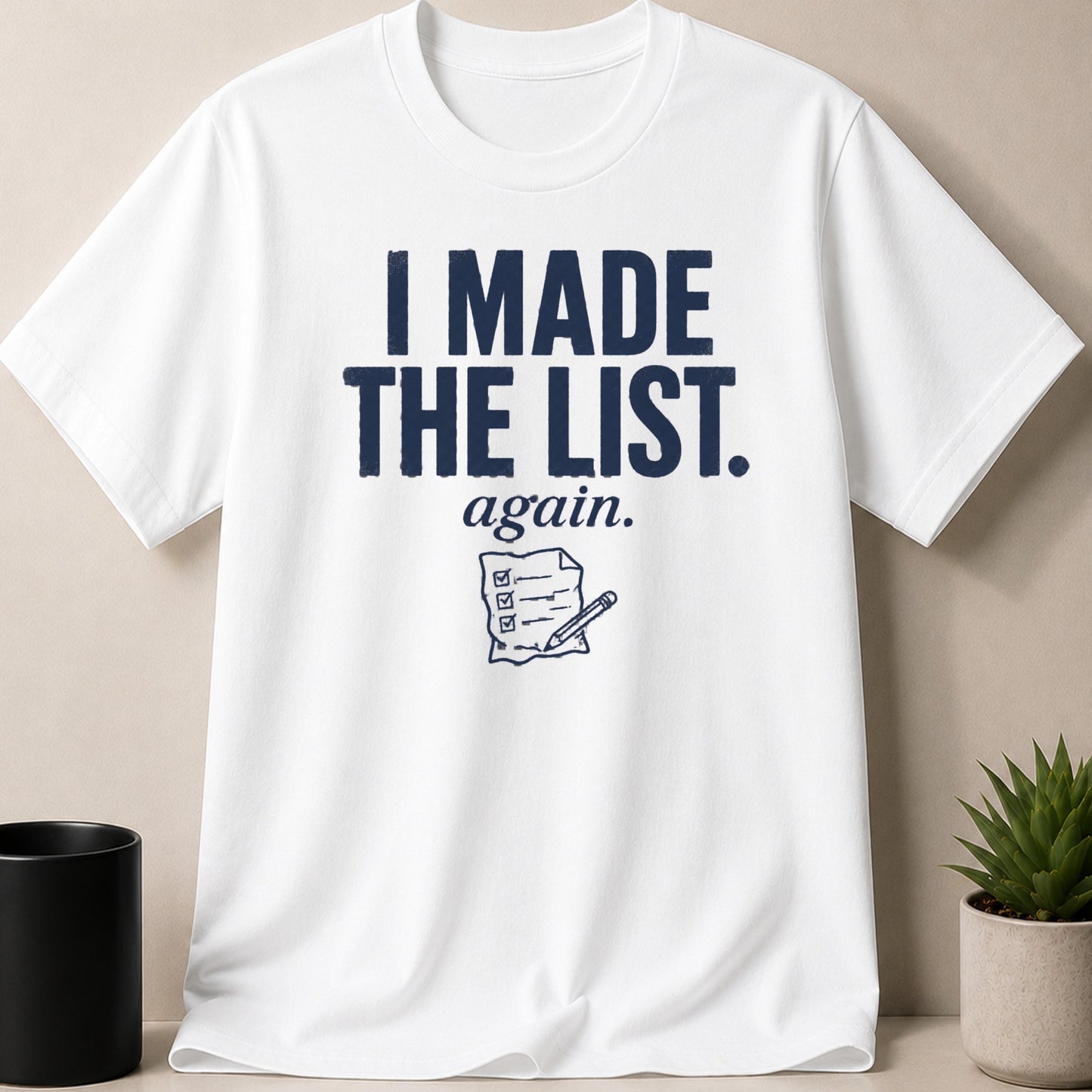 White t-shirt with navy text "I MADE THE LIST. again." and checklist graphic.
