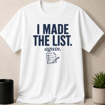 White t-shirt with navy text "I MADE THE LIST. again." and checklist graphic.