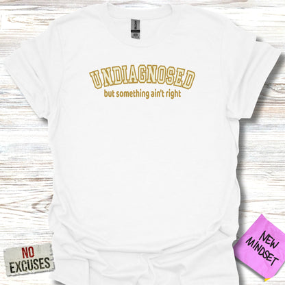 White t-shirt with "UNDIAGNOSED but something ain't right" text.