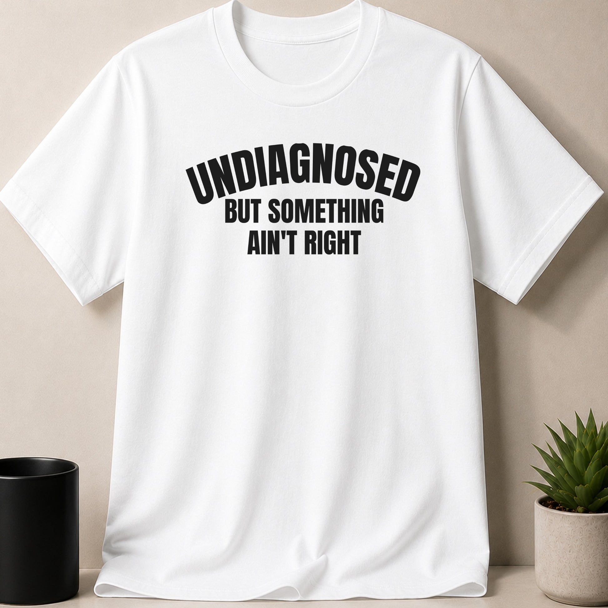White t-shirt with black text that reads "UNDIAGNOSED BUT SOMETHING AIN'T RIGHT".