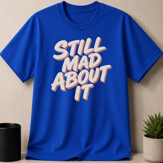 Royal blue t-shirt with white and orange text "STILL MAD ABOUT IT"