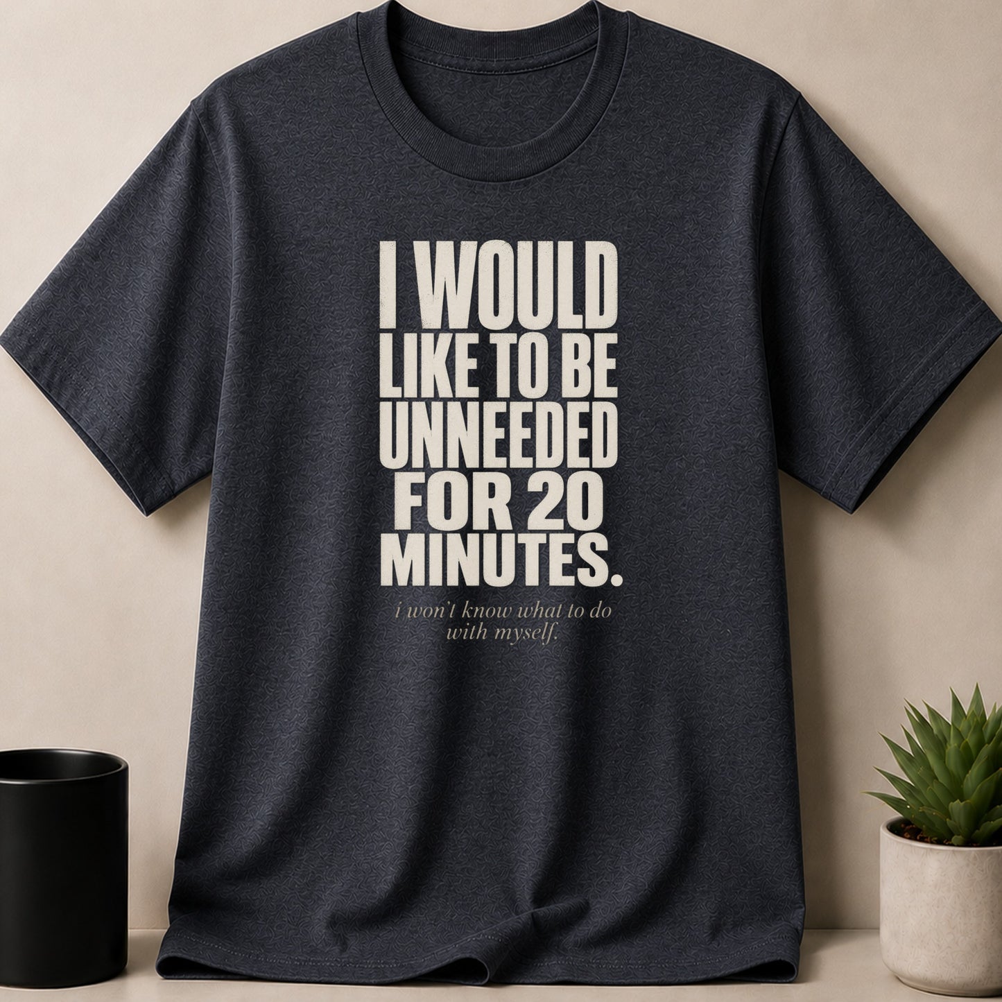 Dark grey t-shirt with "I WOULD LIKE TO BE UNNEEDED FOR 20 MINUTES. i won't know what to do with myself." text.