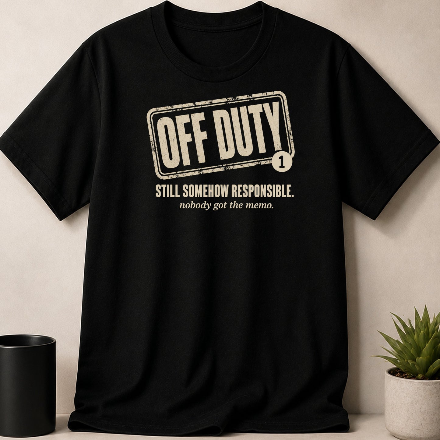 Black t-shirt with "OFF DUTY" and "STILL SOMEHOW RESPONSIBLE. nobody got the memo." text.