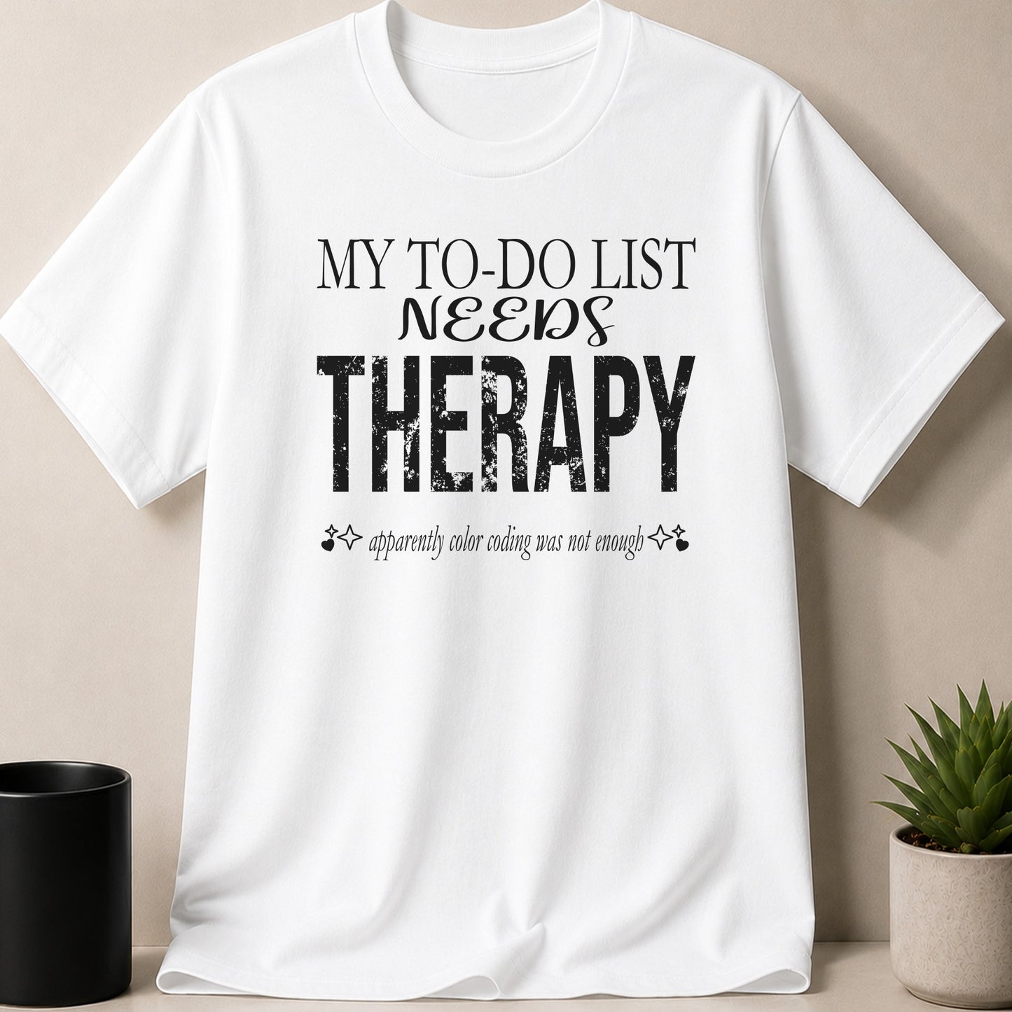 White t-shirt with black text reading "MY TO-DO LIST NEEDS THERAPY" and "apparently color coding was not enough".