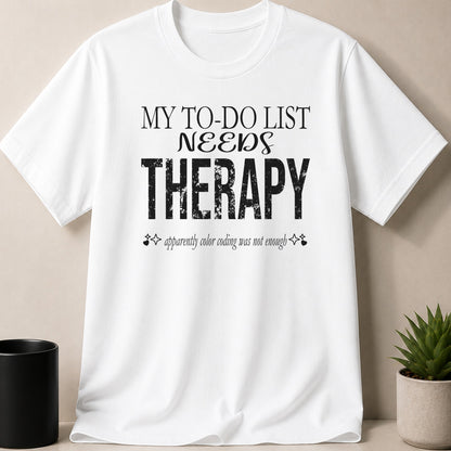 White t-shirt with black text reading "MY TO-DO LIST NEEDS THERAPY" and "apparently color coding was not enough".