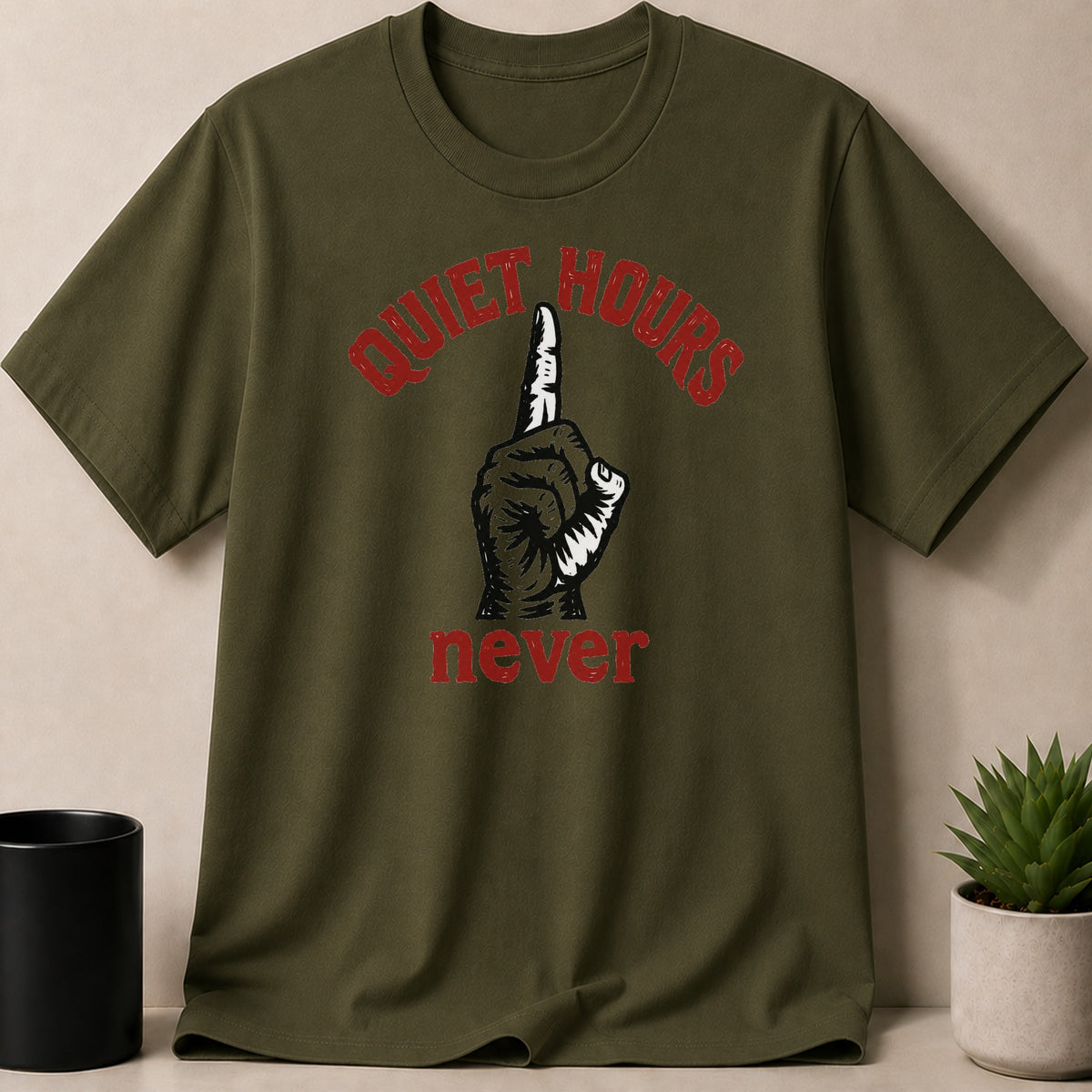Olive green t-shirt with red text "QUIET HOURS" above a hand with one finger up, and "never" below.