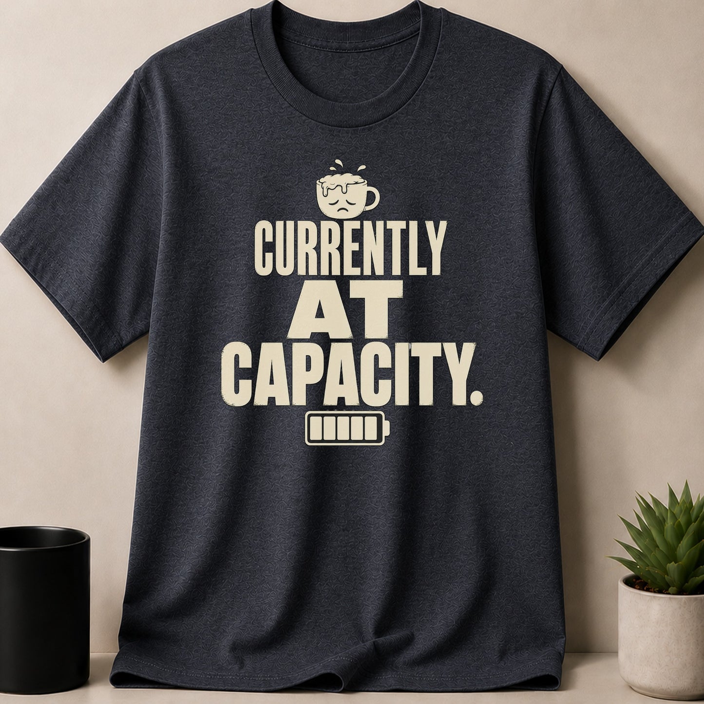 Charlcoal t-shirt with text 'Currently At Capacity' and low battery symbol.
