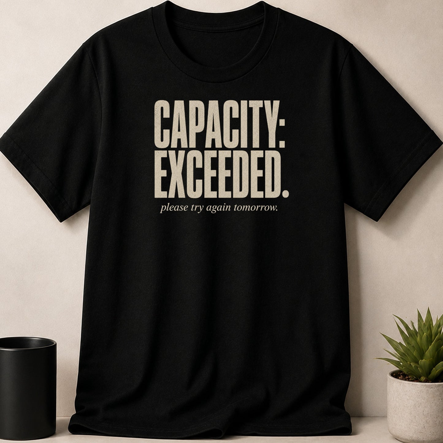 Black t-shirt with "CAPACITY: EXCEEDED. please try again tomorrow." text.
