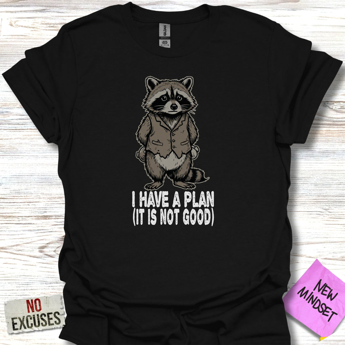 Black t-shirt with a raccoon illustration and "I HAVE A PLAN (IT IS NOT GOOD)" text.