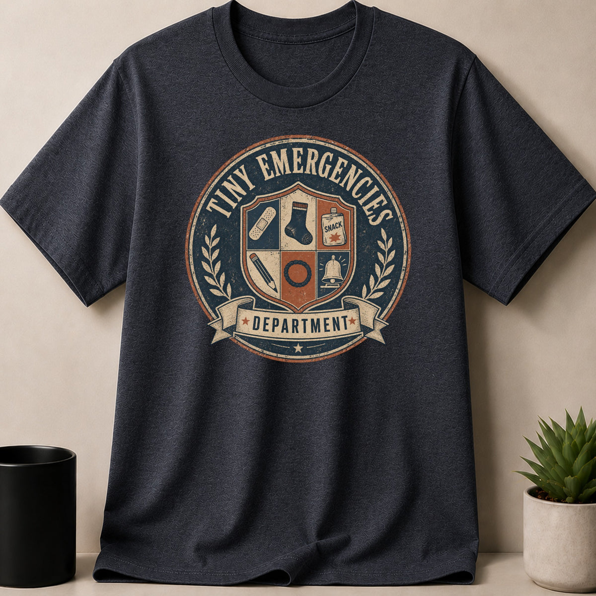 Dark gray t-shirt with a round badge for the "Tiny Emergencies Department".